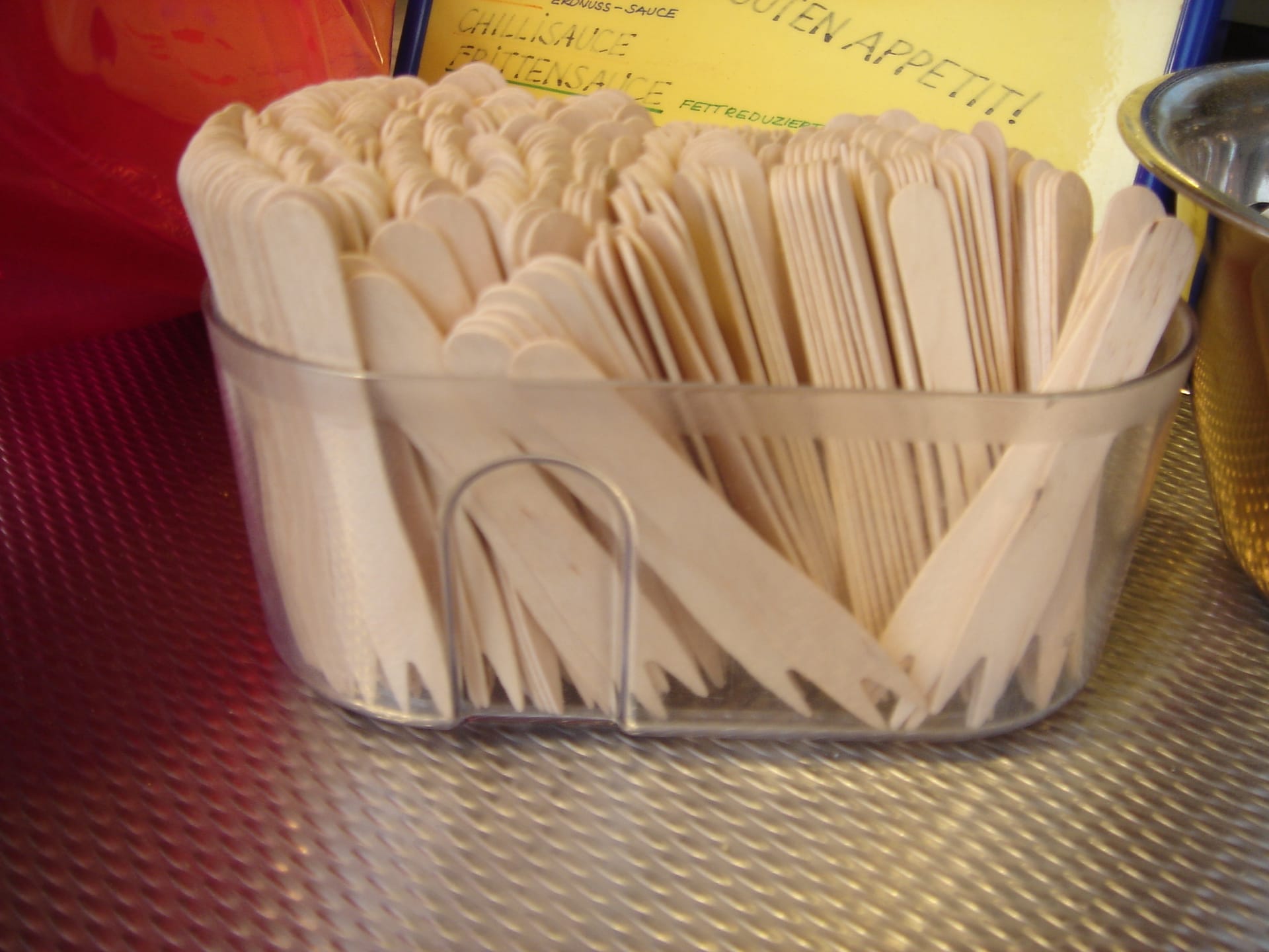 A set of wooden two-pronged forks used for eating currywurst.